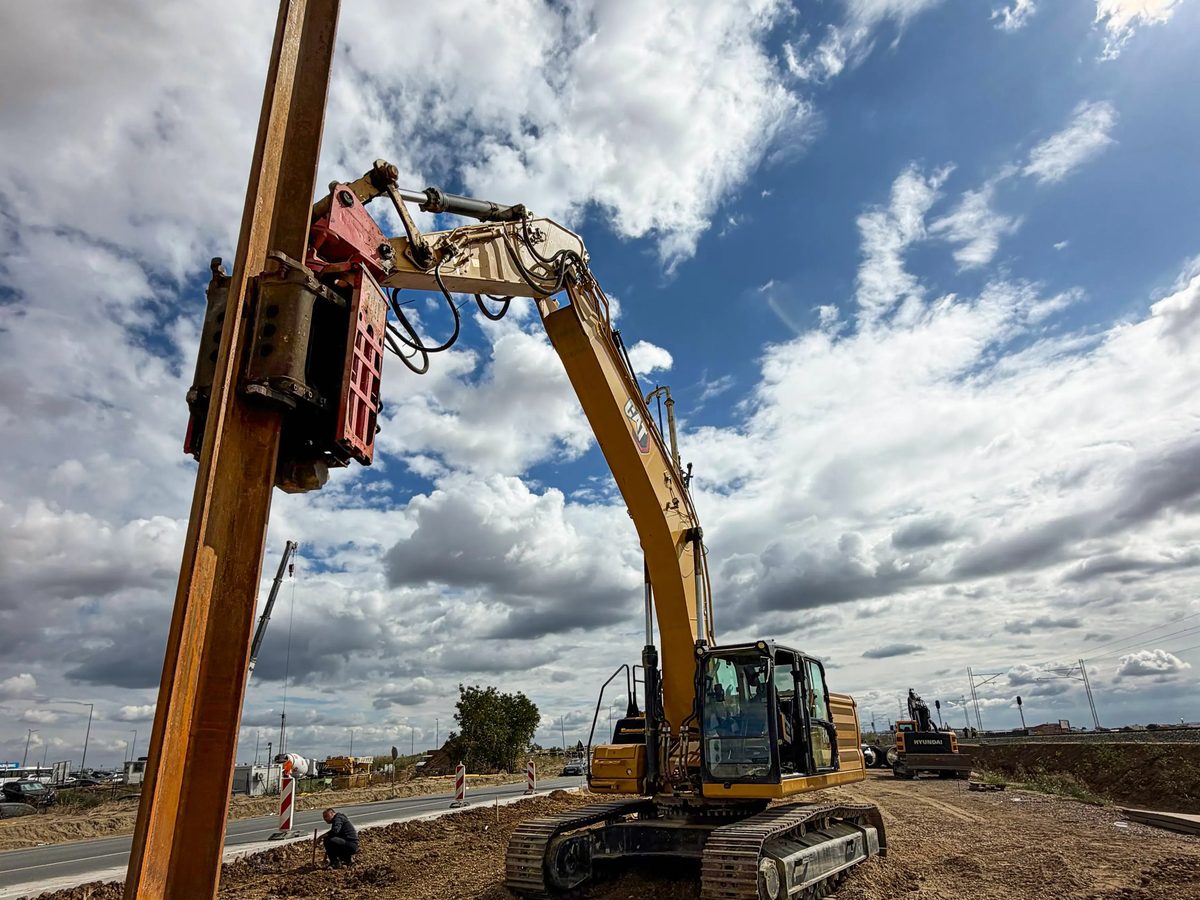 CAT 336 excavator with a side grip vibro hammer holding a sheet pile near Belgrade airport