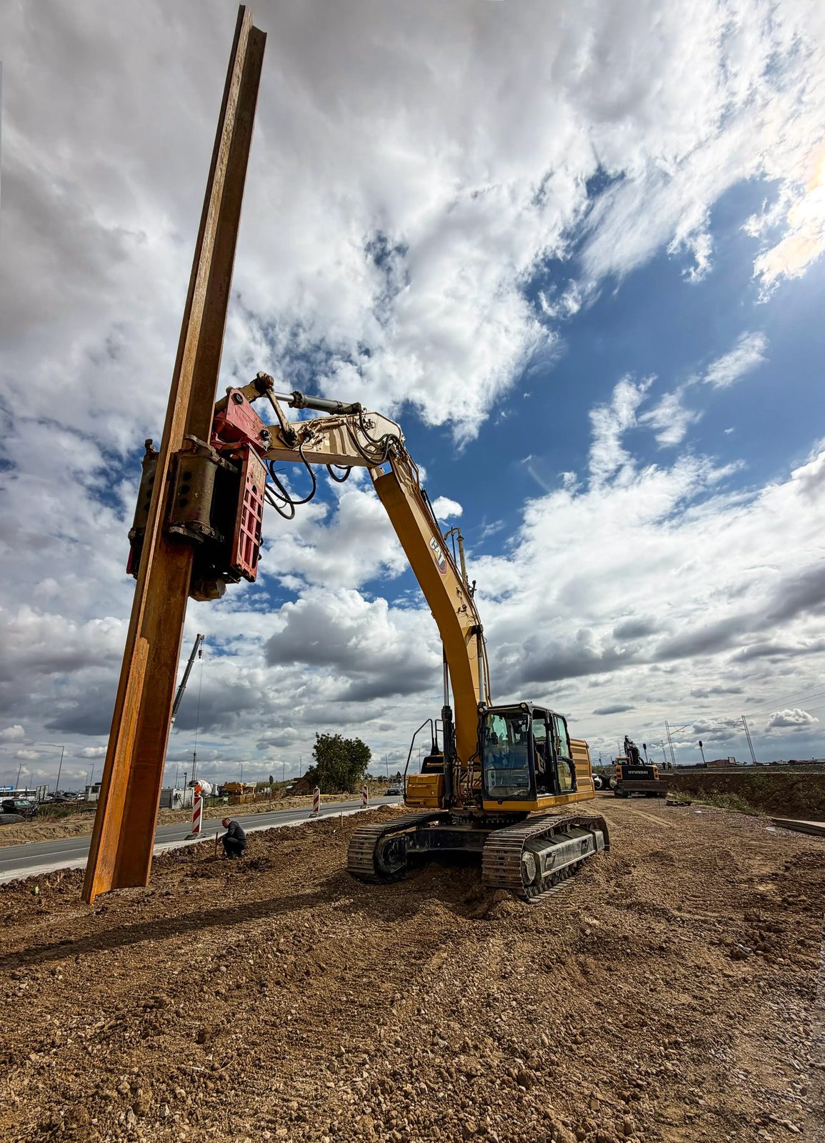 CAT 336 excavator with a side grip vibro hammer holding a sheet pile near Belgrade airport