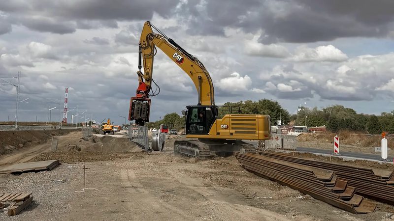 CAT 336 excavator with a side grip vibro hammer holding a sheet pile near Belgrade airport